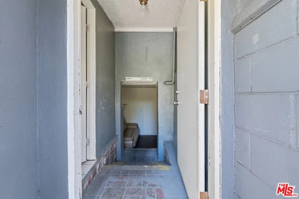 a view of a hallway with furniture and wooden floor