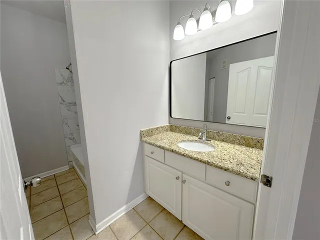 a bathroom with a granite countertop sink and a mirror