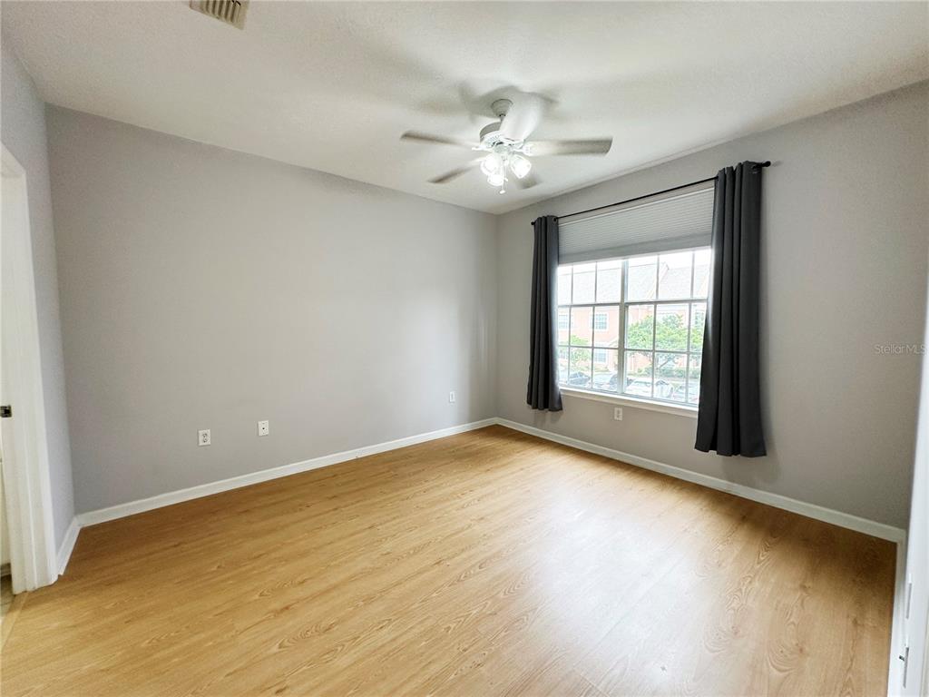 12843 Madison Pointe Circle, Unit 201 Orlando, FL 32821 - Photo 20 of 53 a view of an empty room with chandelier fan and wooden floor