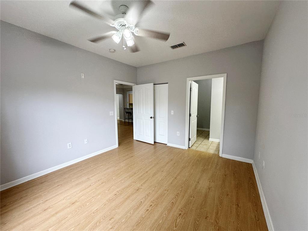 12843 Madison Pointe Circle, Unit 201 Orlando, FL 32821 - Photo 21 of 53 a view of an empty room with chandelier fan and wooden floor