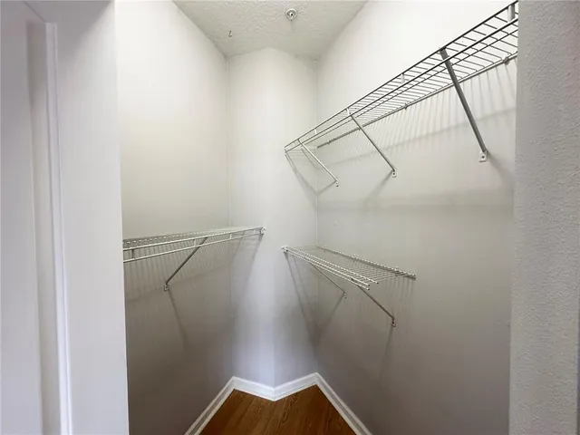 a view of walk in closet with racks on the wall