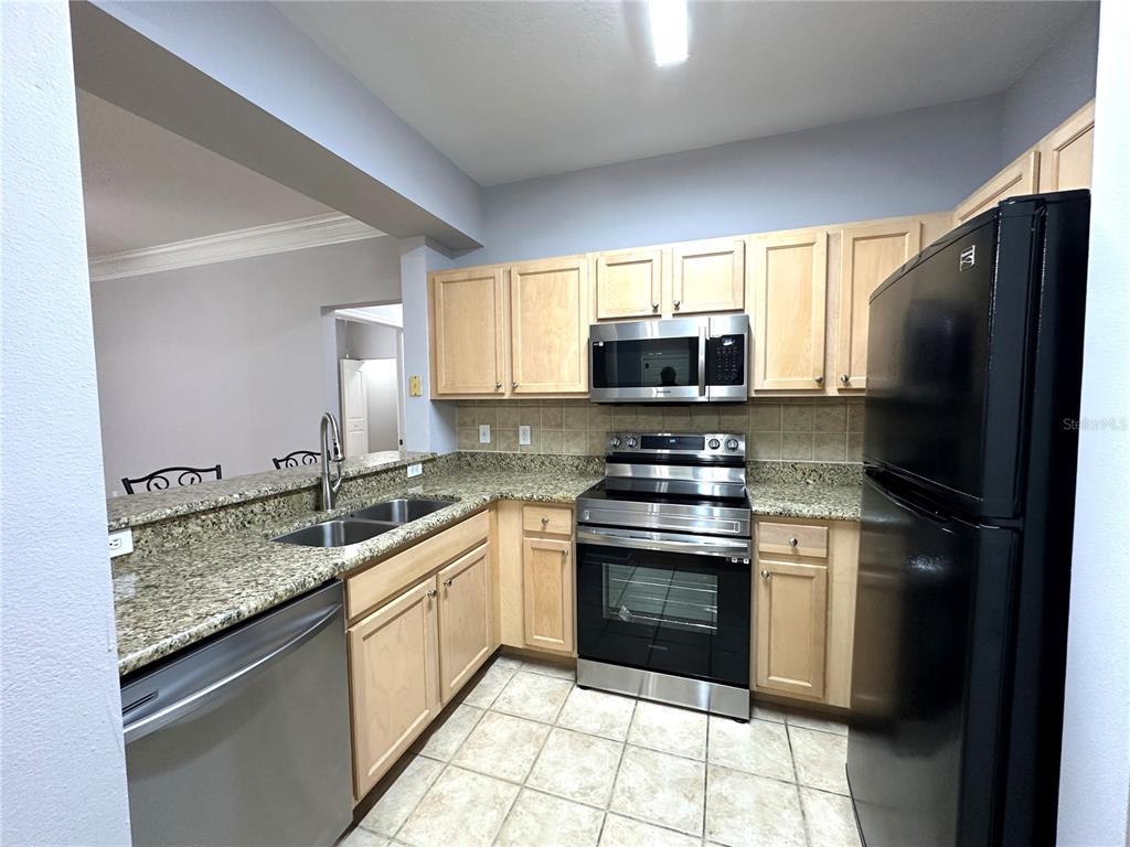 12843 Madison Pointe Circle, Unit 201 Orlando, FL 32821 - Photo 3 of 53 a kitchen with a sink stove and refrigerator