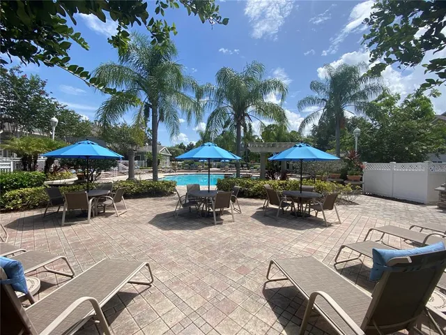 a view of patio with chairs and table under an umbrella