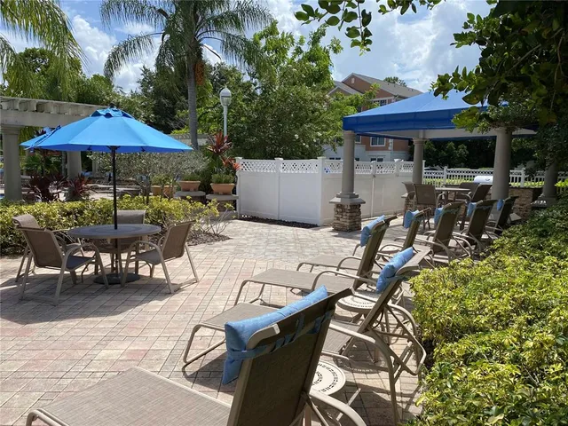 a view of a patio with a table and chairs under an umbrella