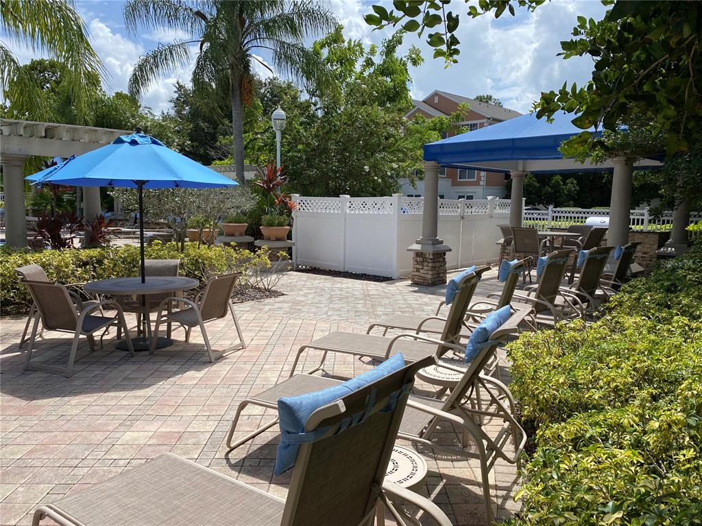 12843 Madison Pointe Circle, Unit 201 Orlando, FL 32821 - Photo 33 of 53 a view of a patio with table and chairs under an umbrella