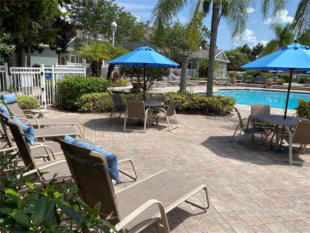 12843 Madison Pointe Circle, Unit 201 Orlando, FL 32821 - Photo 34 of 53 a view of a patio with a table and chairs under an umbrella