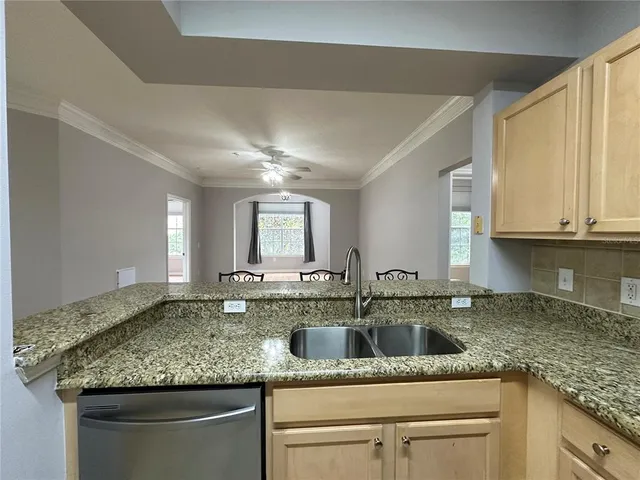 a kitchen with granite countertop a sink and cabinets