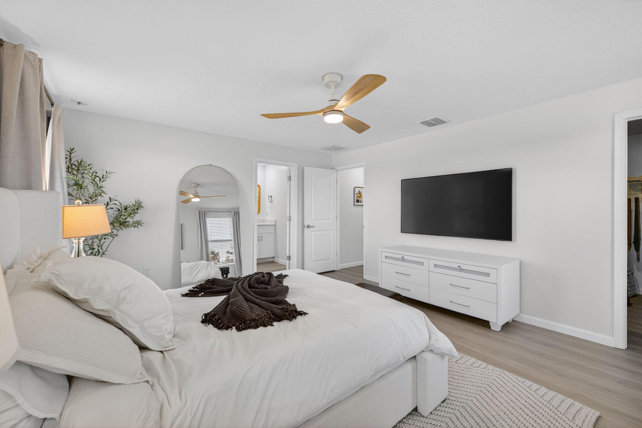 5624 Southeast Edgewater Circle Stuart, FL 34997 - Photo 16 of 33 a bedroom with a bed a mirror on dresser and a flat screen tv