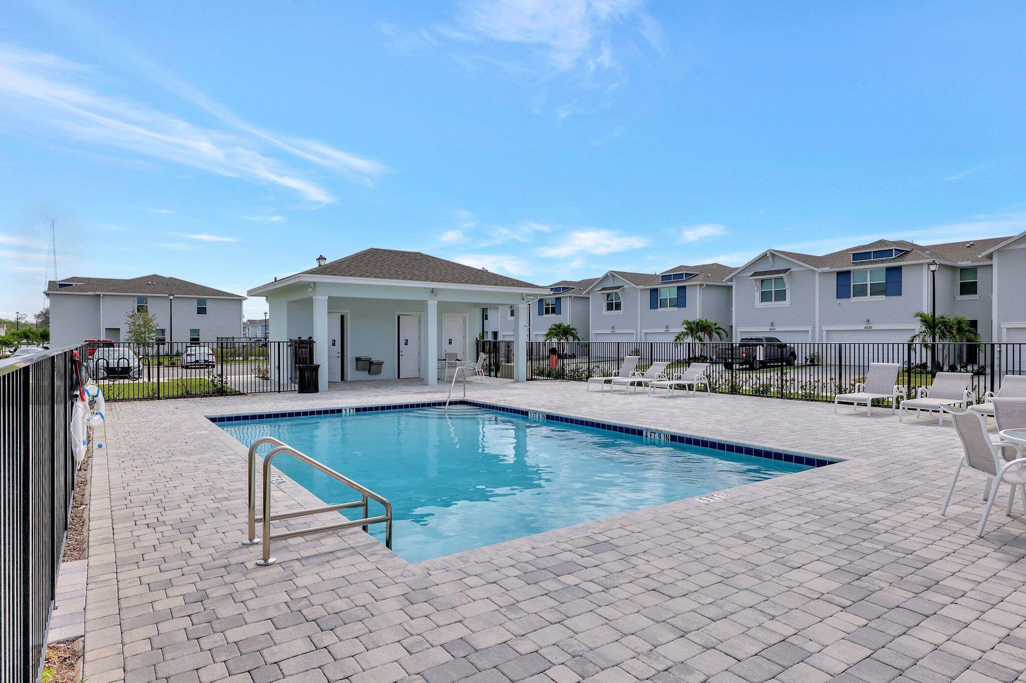 5624 Southeast Edgewater Circle Stuart, FL 34997 - Photo 33 of 33 a front view of a house with swimming pool and porch