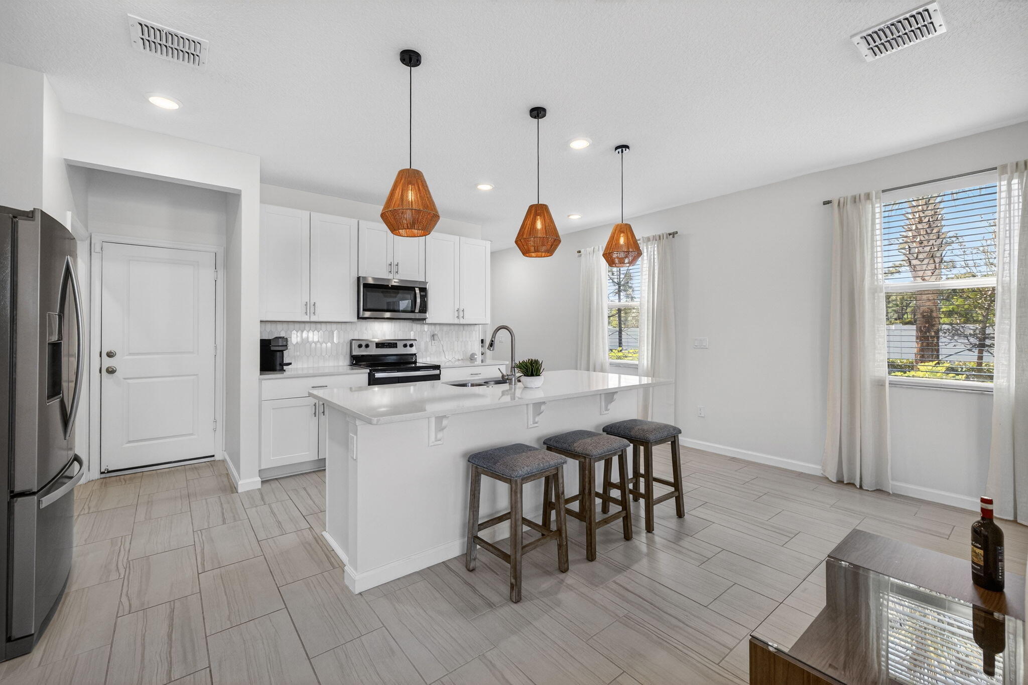 5624 Southeast Edgewater Circle Stuart, FL 34997 - Photo 5 of 33 a kitchen with stainless steel appliances granite countertop a stove a sink a refrigerator and a dining table with wooden floor