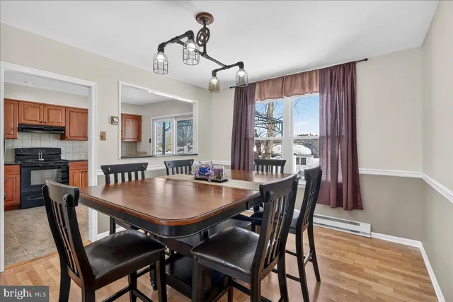 a large white kitchen with a sink and a large mirror next to a window