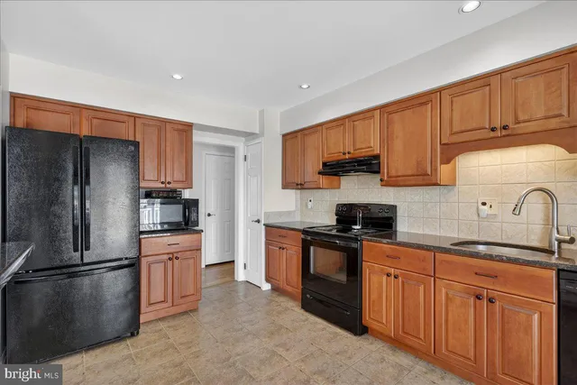 a kitchen with stainless steel appliances granite countertop a refrigerator stove and sink