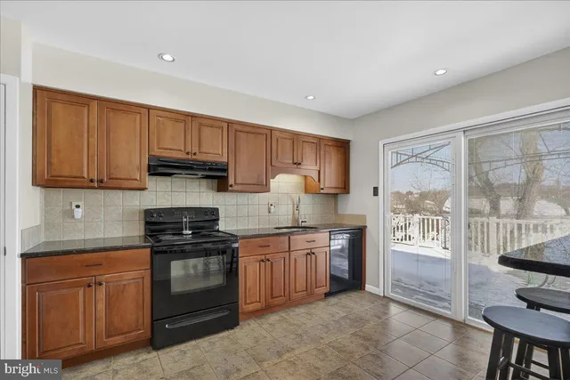 a kitchen with stainless steel appliances granite countertop a refrigerator stove a sink dishwasher and microwave