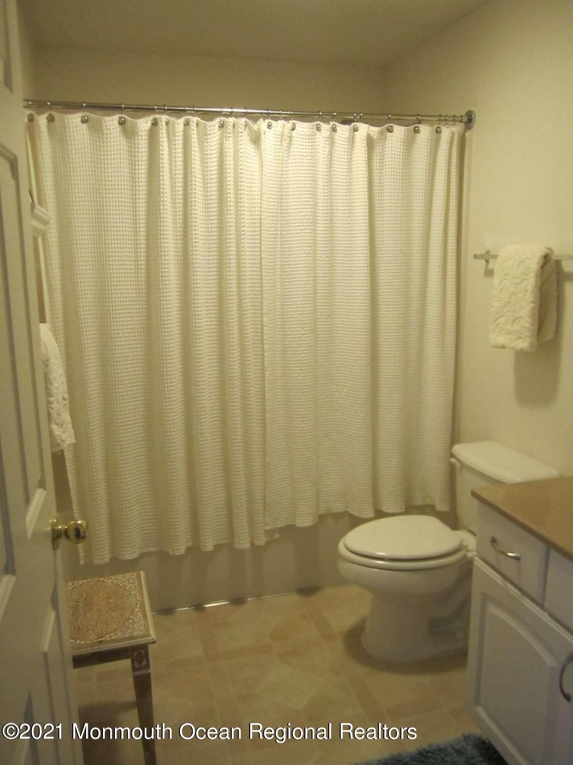 111 Marlin Road Tuckerton, NJ 08087 - Photo 14 of 23 a bathroom with a toilet and a shower curtain