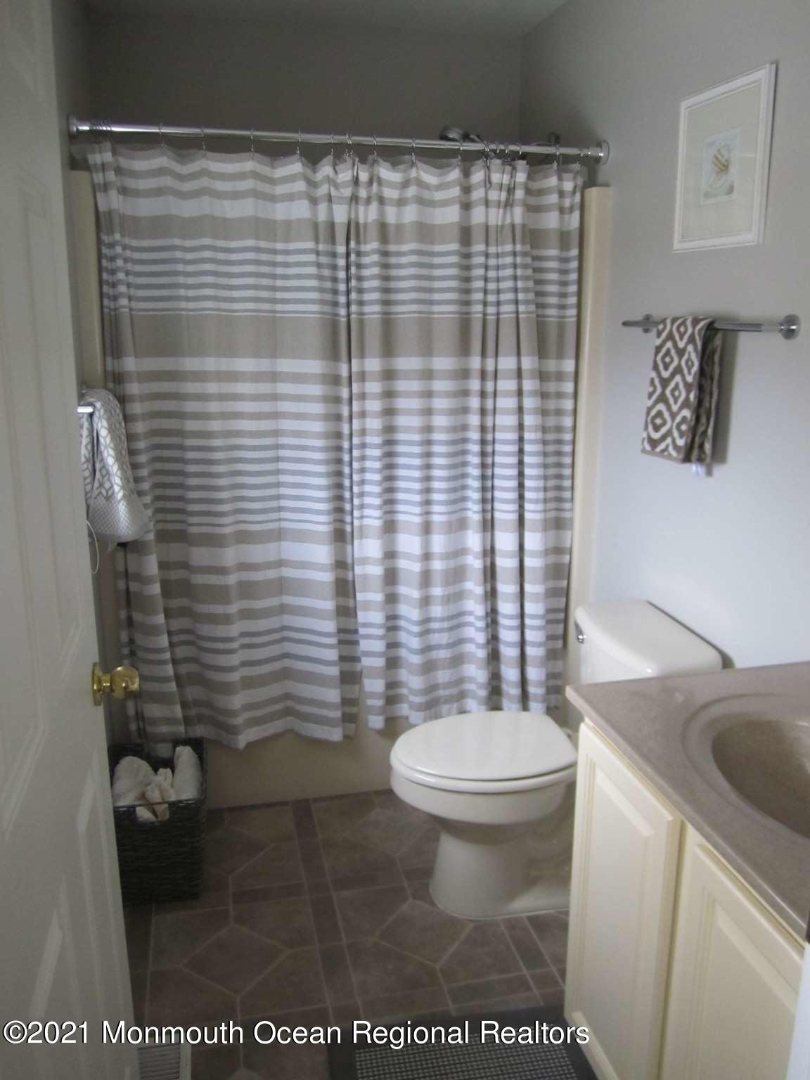 111 Marlin Road Tuckerton, NJ 08087 - Photo 8 of 23 a bathroom with a toilet and a shower curtain