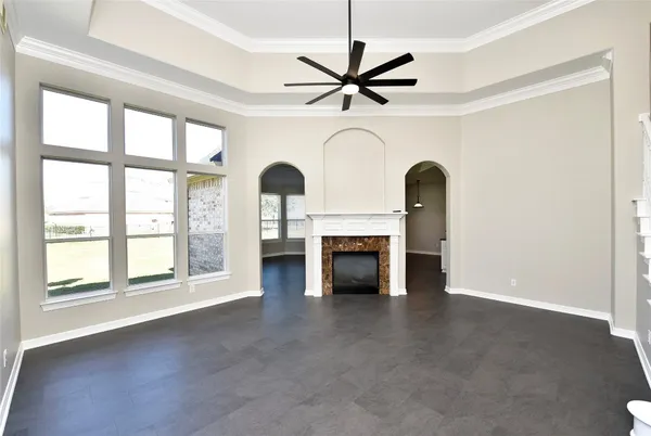 a living room with furniture a fireplace and a ceiling fan