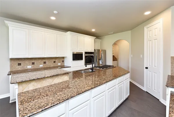 a bathroom with bathtub a sink and a large mirror