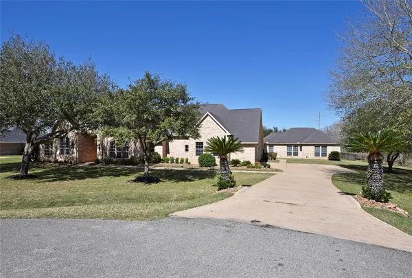 a front view of a house with a yard and trees