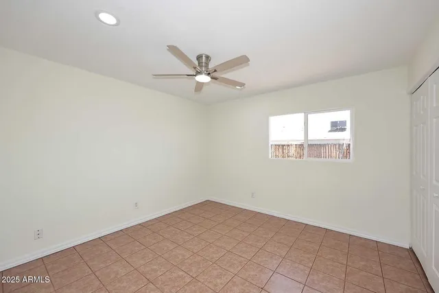 an empty room with a window and a fan