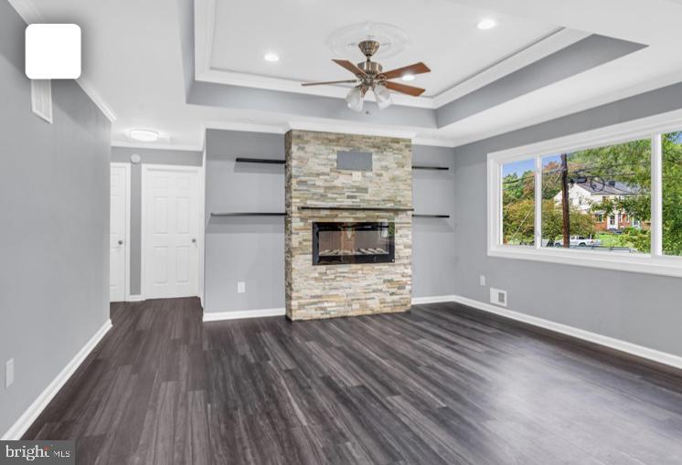 6701 Furman Parkway Riverdale, MD 20737 - Photo 8 of 9 an empty room with windows fireplace and a ceiling fan