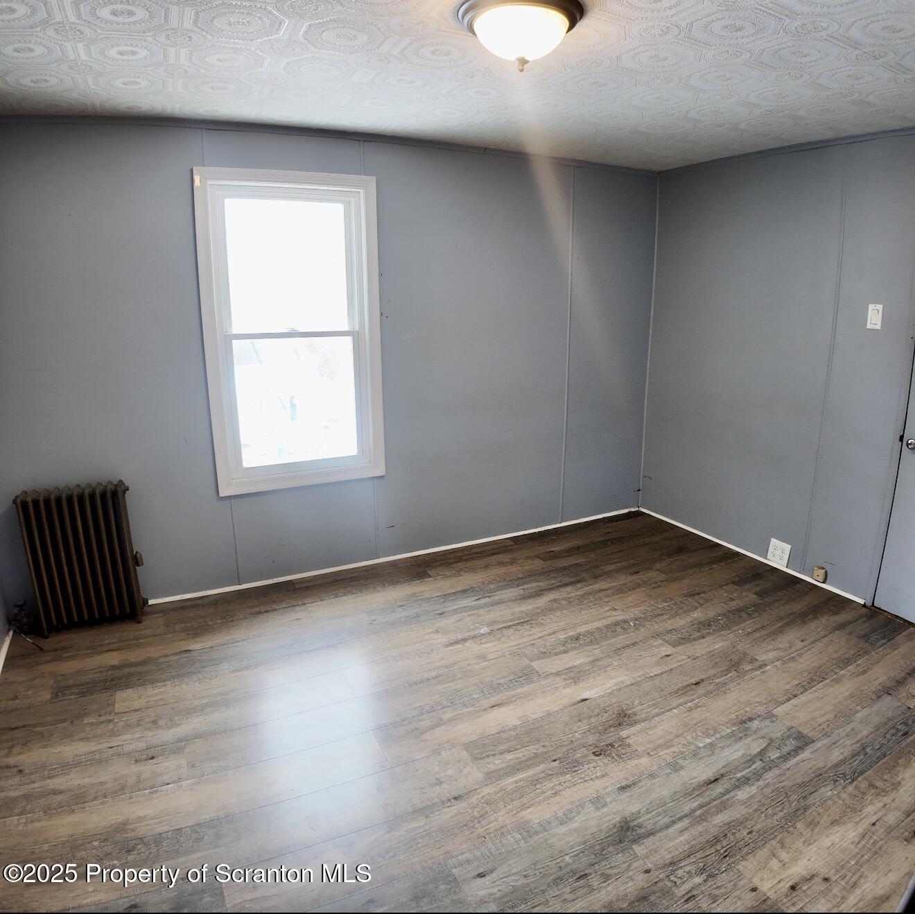 58 Owego Street Simpson, PA 18407 - Photo 12 of 16 an empty room with wooden floor and windows