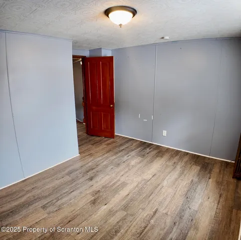an empty room with wooden floor and glass door