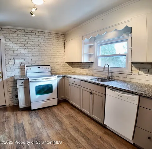 a kitchen with a stove top oven sink and window