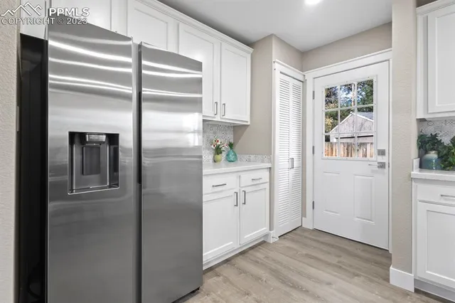 a kitchen with white cabinets and window
