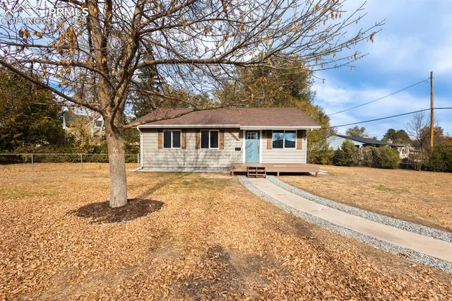 a house with large trees and outdoor space