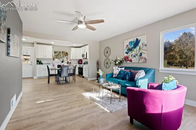 a living room with furniture and a dining table with kitchen view