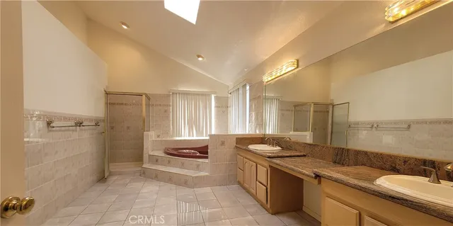 a large bathroom with a granite countertop sink a toilet a mirror and shower