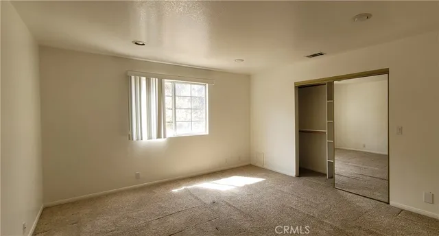 an empty room with windows and closet
