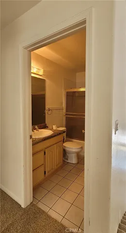a bathroom with a granite countertop sink a toilet and shower