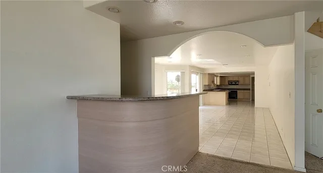 a view of empty room with kitchen