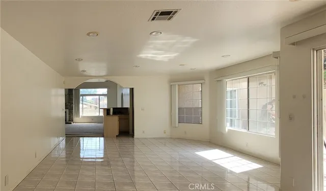 a view of an empty room with window and cabinet