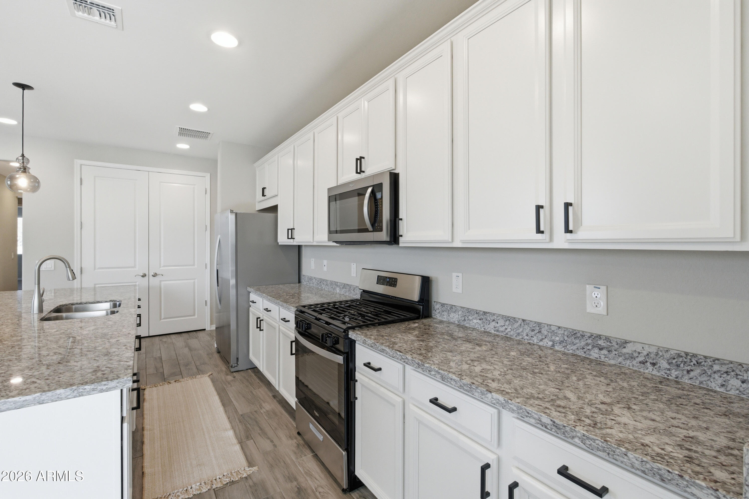 22445 East Marsh Road Queen Creek, AZ 85142 - Photo 32 of 71 a kitchen with granite countertop white cabinets and stainless steel appliances