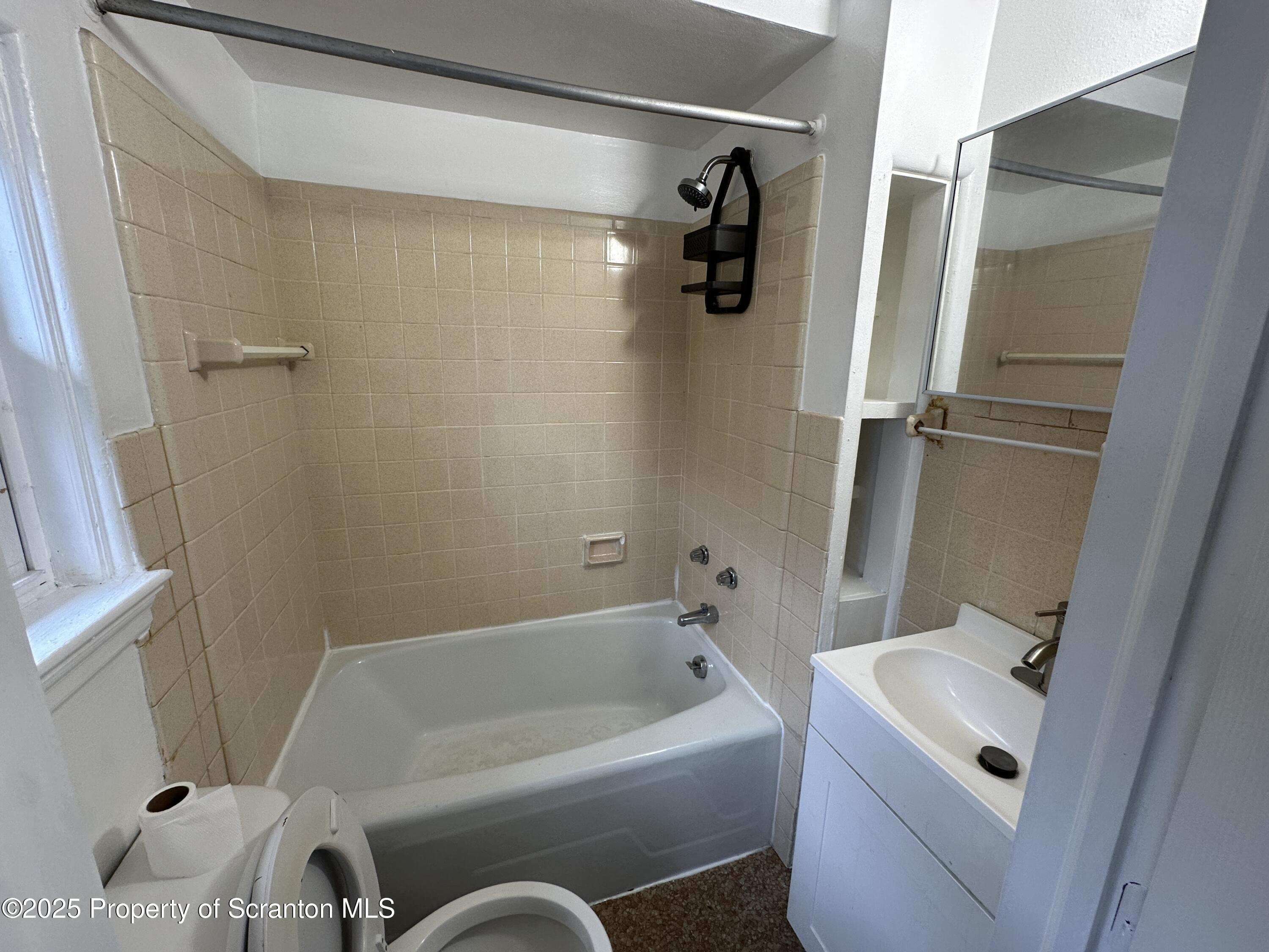 306 Wyoming Avenue, Unit H Wyoming, PA 18644 - Photo 3 of 4 a bathroom with a tub sink and toilet