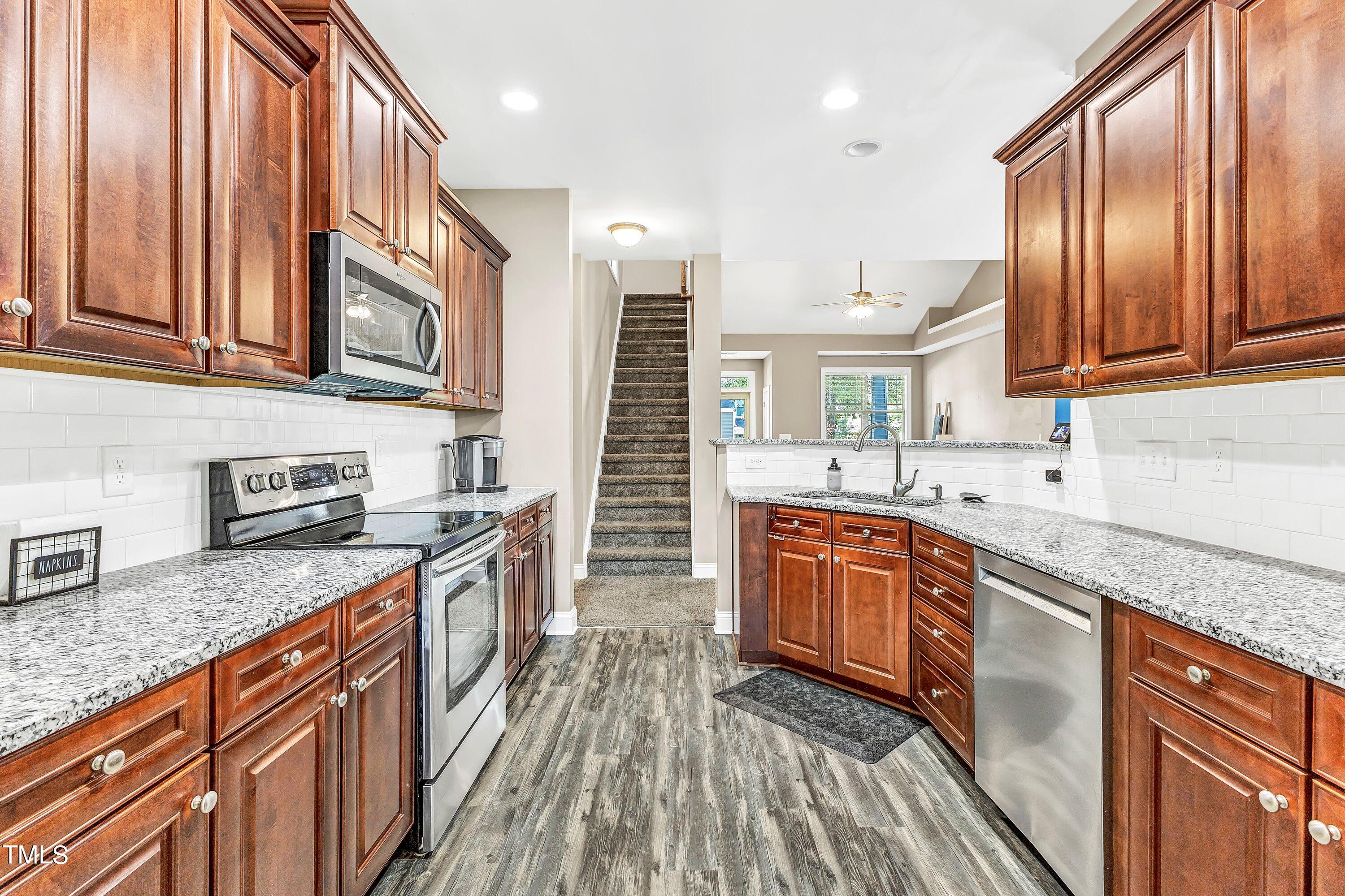 4151 White Kestrel Drive Raleigh, NC 27616 - Photo 13 of 37 a kitchen with stainless steel appliances granite countertop a sink a stove and cabinets