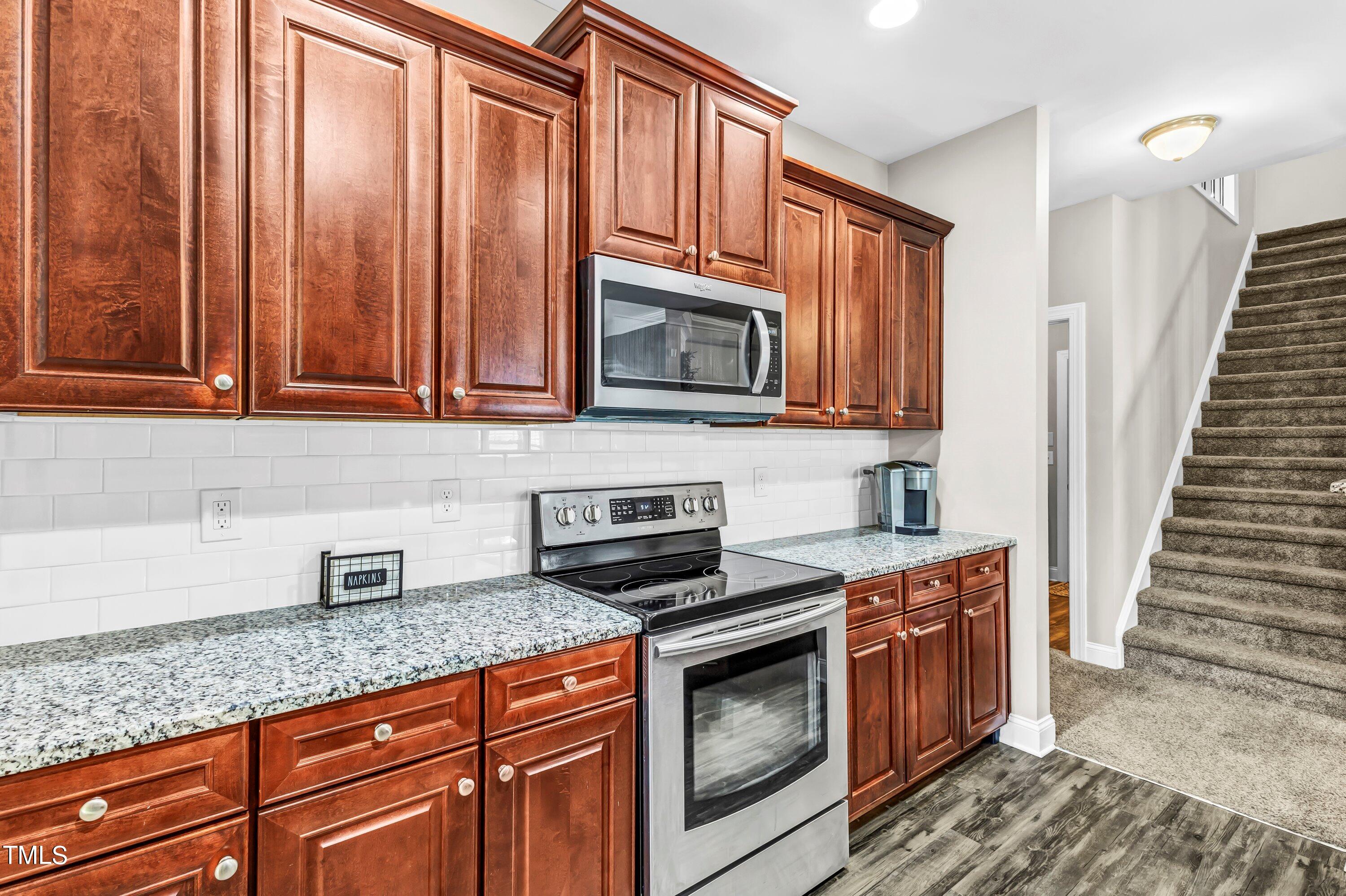 4151 White Kestrel Drive Raleigh, NC 27616 - Photo 14 of 37 a kitchen with granite countertop wooden cabinets stainless steel appliances and a counter space
