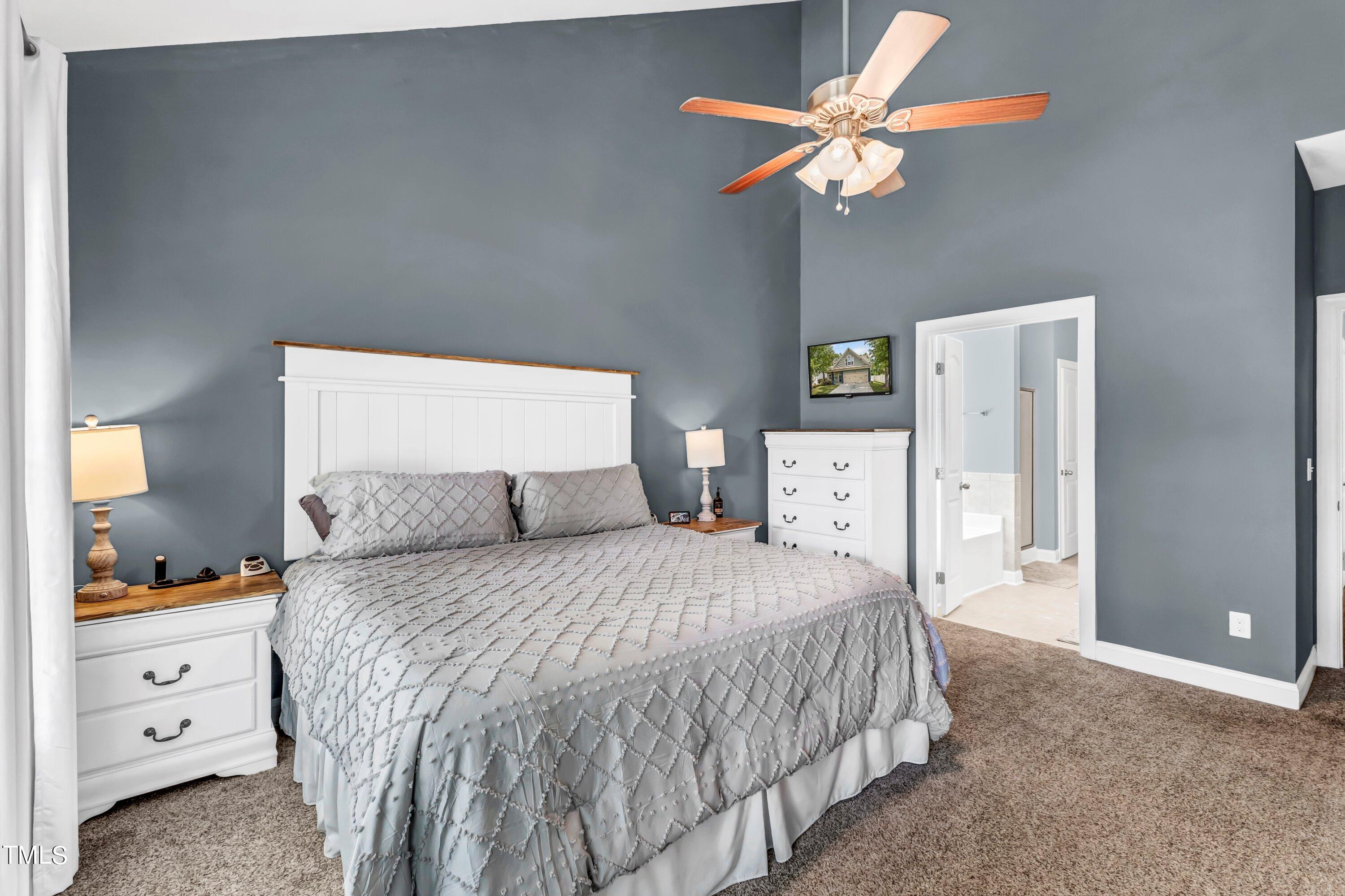 4151 White Kestrel Drive Raleigh, NC 27616 - Photo 17 of 37 a bedroom with a large bed and a chandelier