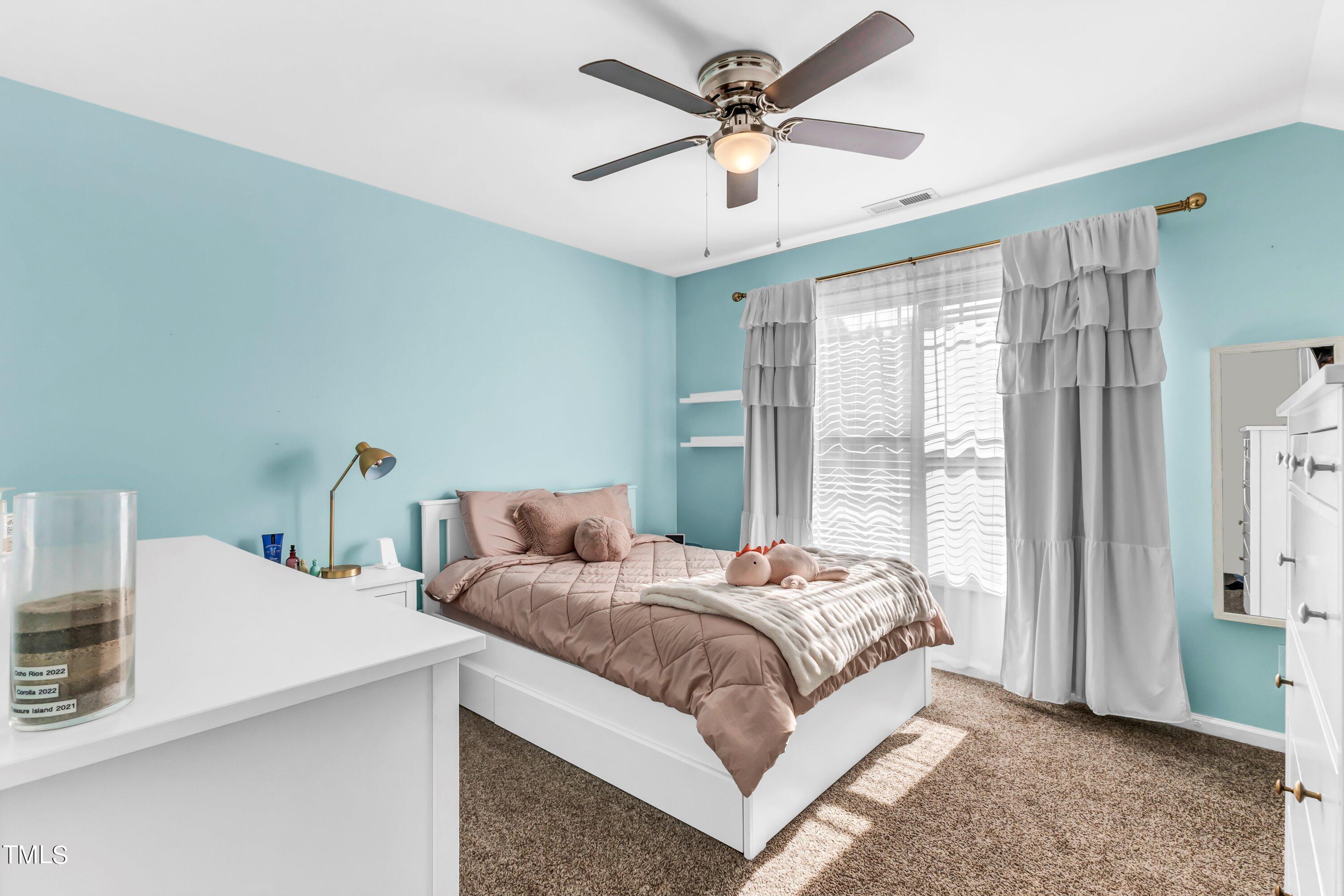 4151 White Kestrel Drive Raleigh, NC 27616 - Photo 26 of 37 a bedroom with a bed a chandelier and a window