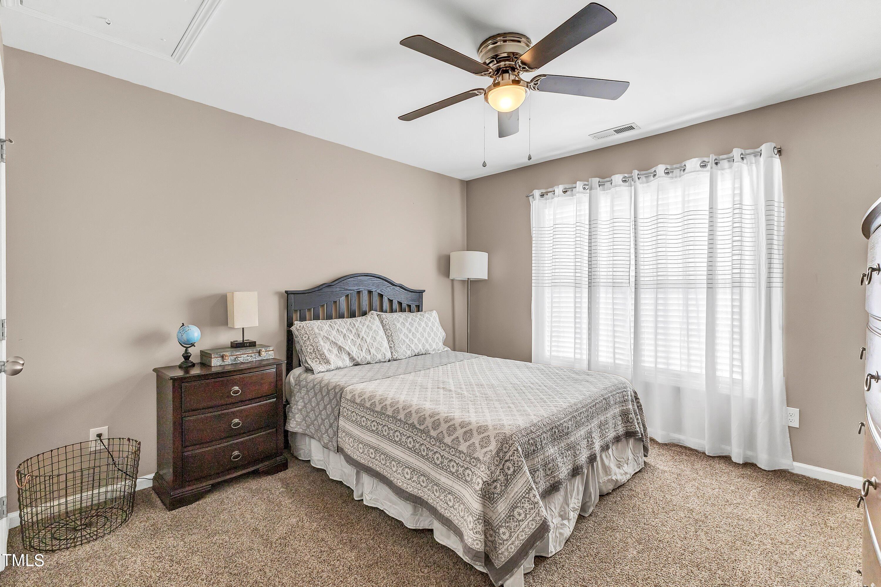 4151 White Kestrel Drive Raleigh, NC 27616 - Photo 28 of 37 a bedroom with a bed a chandelier and a window