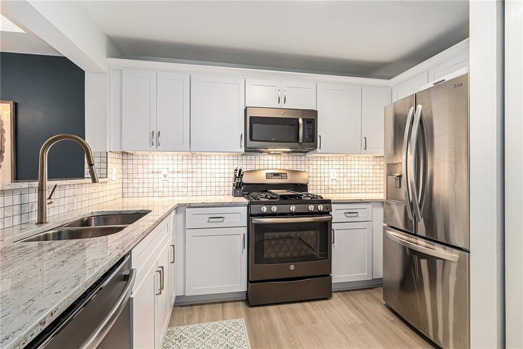 220 Renaissance Parkway Northeast, Unit 1211 Atlanta, GA 30308 - Photo 12 of 24 a kitchen with stainless steel appliances granite countertop a refrigerator stove and sink