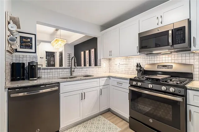 a kitchen with stainless steel appliances a stove a sink and a microwave