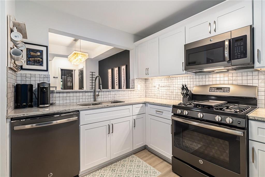 220 Renaissance Parkway Northeast, Unit 1211 Atlanta, GA 30308 - Photo 13 of 24 a kitchen with stainless steel appliances a stove a sink and a microwave