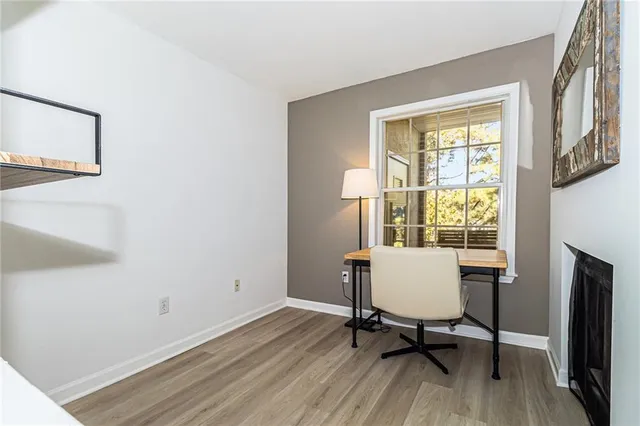 a view of a workspace with furniture and a window
