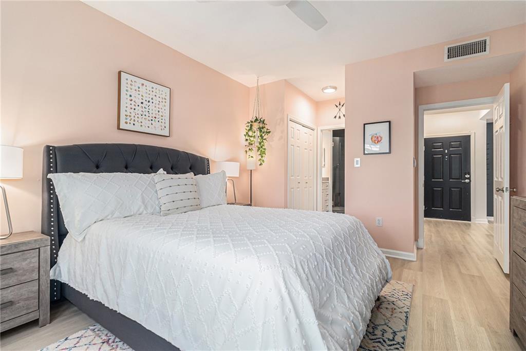 220 Renaissance Parkway Northeast, Unit 1211 Atlanta, GA 30308 - Photo 16 of 24 a bedroom with a large bed and a chandelier