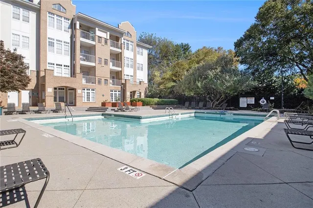 a view of swimming pool with outdoor seating and a pathway
