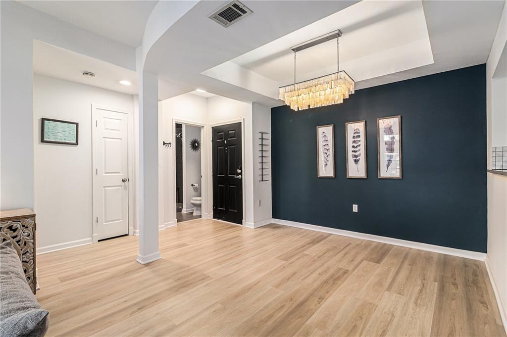 220 Renaissance Parkway Northeast, Unit 1211 Atlanta, GA 30308 - Photo 7 of 24 a view of an empty room with a chandelier fan and a bathroom