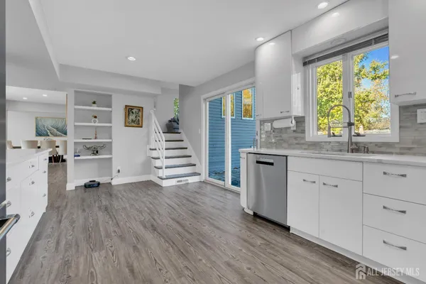 a kitchen with wooden floors and white walls